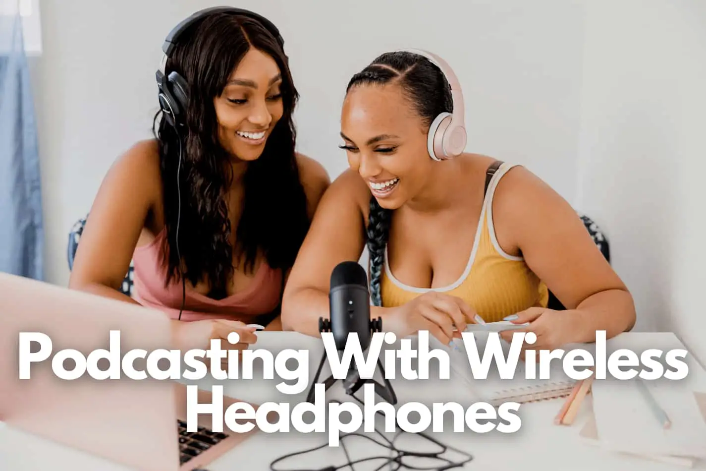 Two speaking on a podcast microphone one using wireless headphones